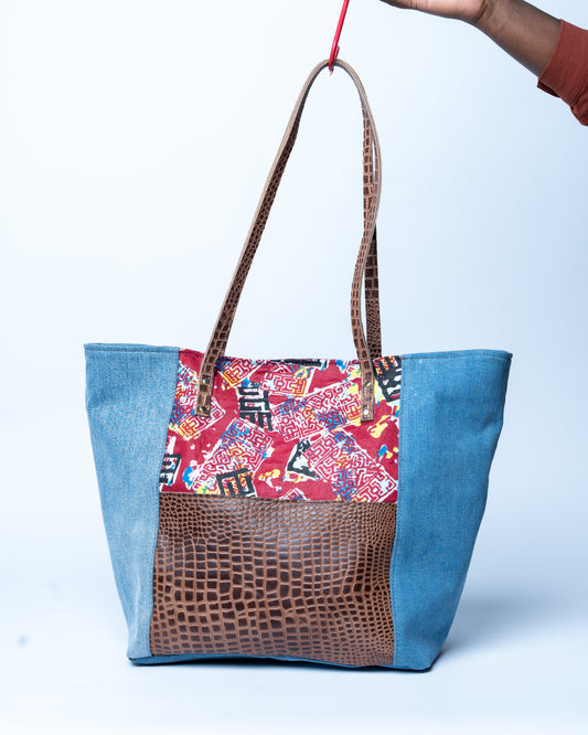 Multicolored tote bag with patterned top section on a white background