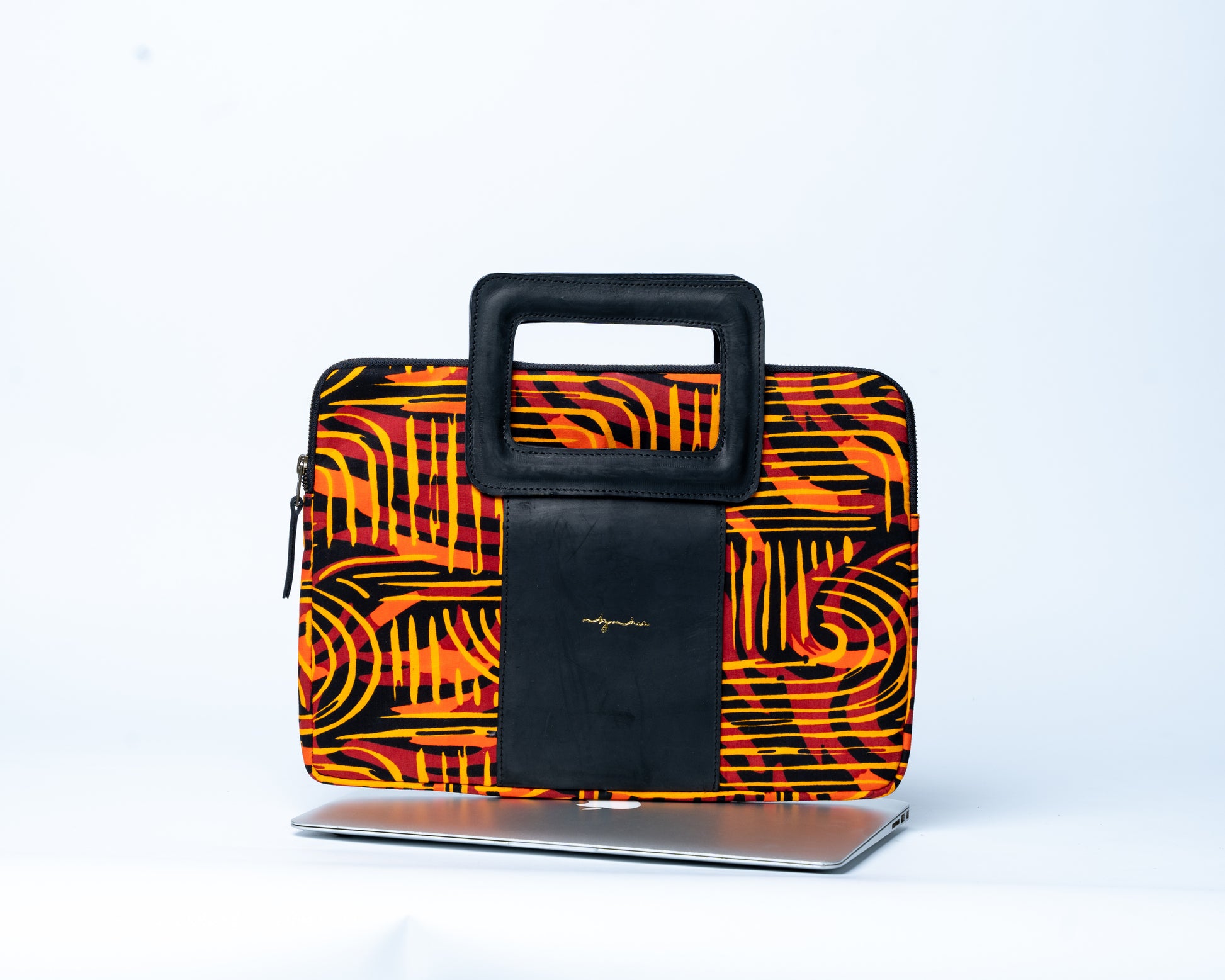 Laptop sleeve with orange and black abstract pattern on a white background
