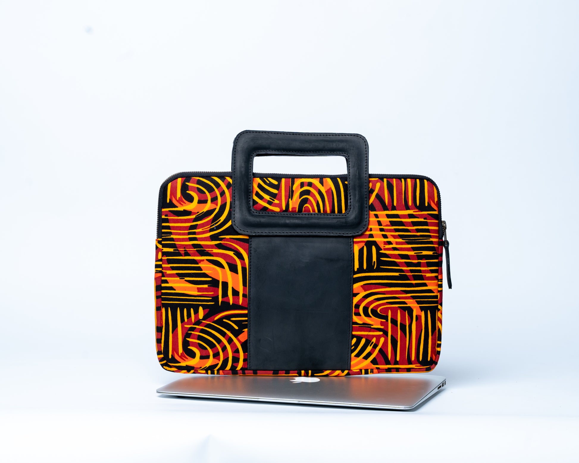 Laptop sleeve with orange and black abstract pattern on a white background