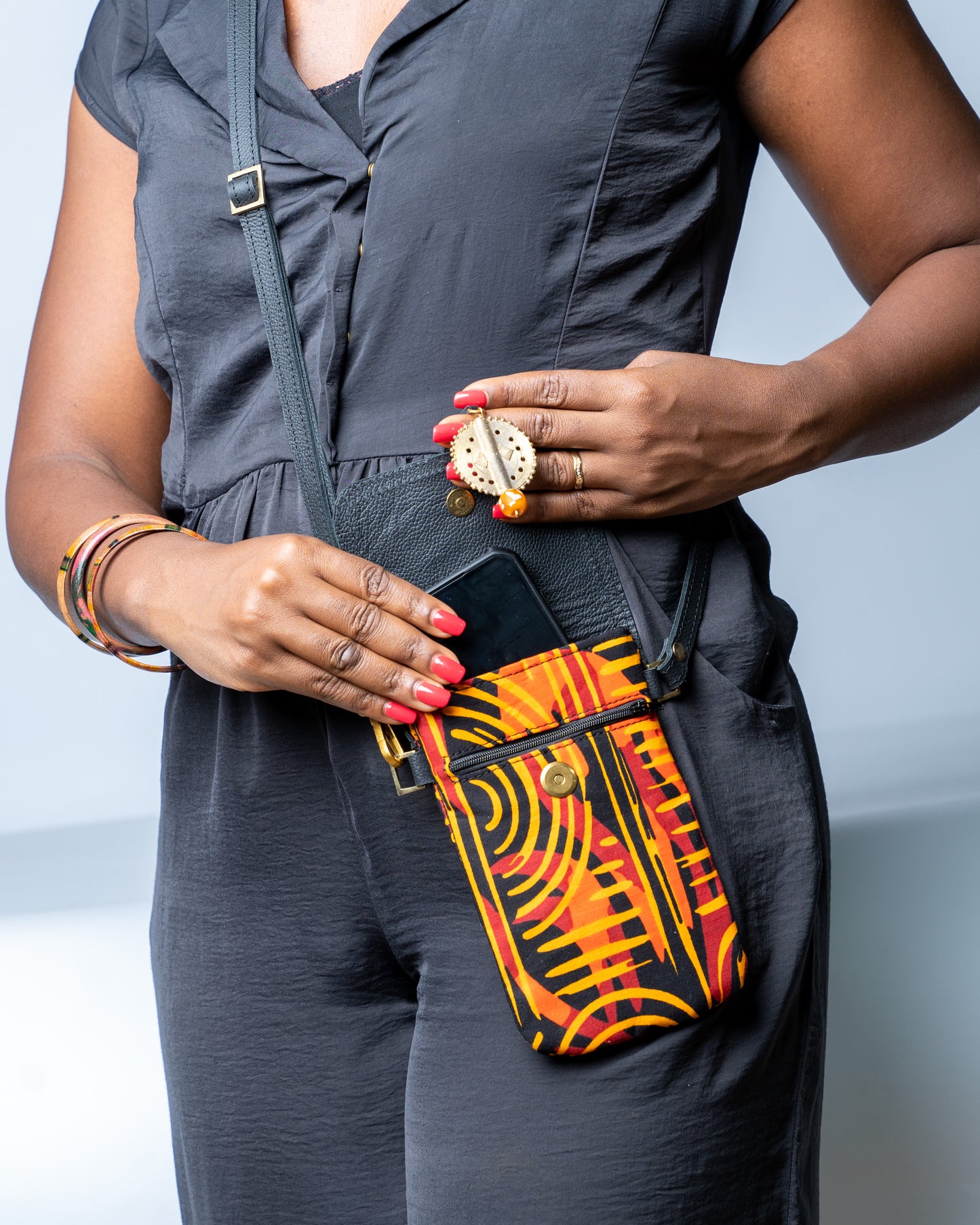 Person holding a colorful patterned bag with a plain background