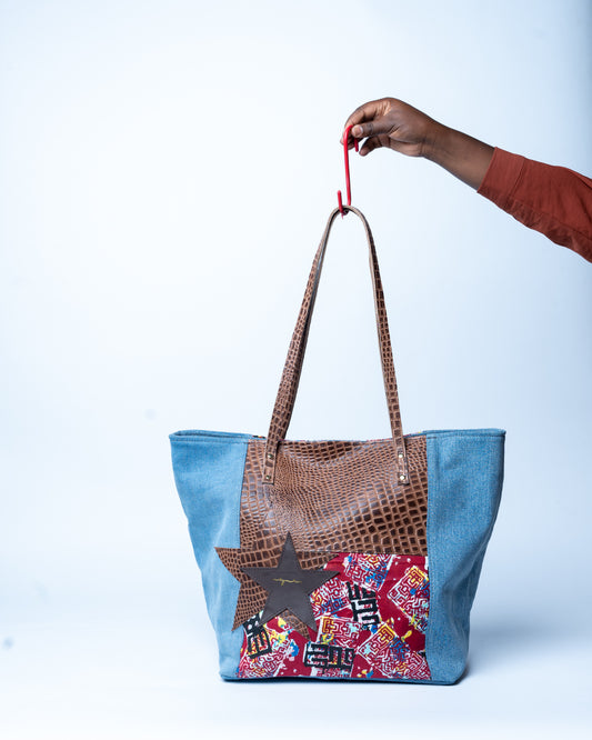 Tote bag with brown handle and colorful patchwork design on a white background