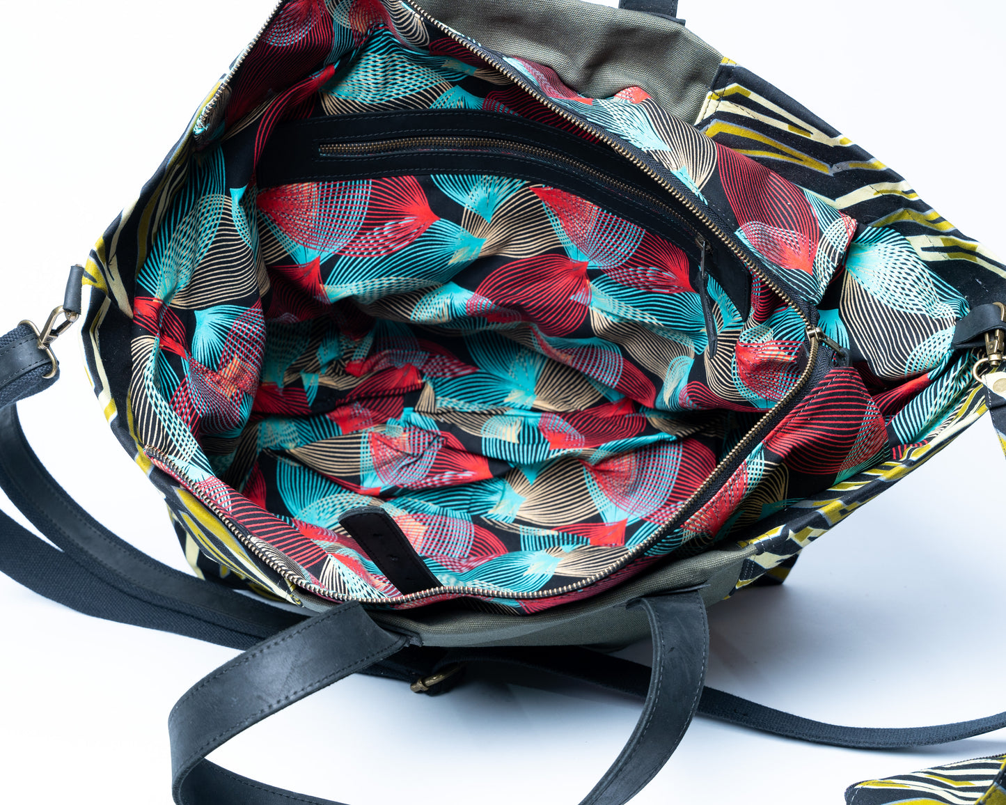 Colorful patterned bag with black straps on a white background