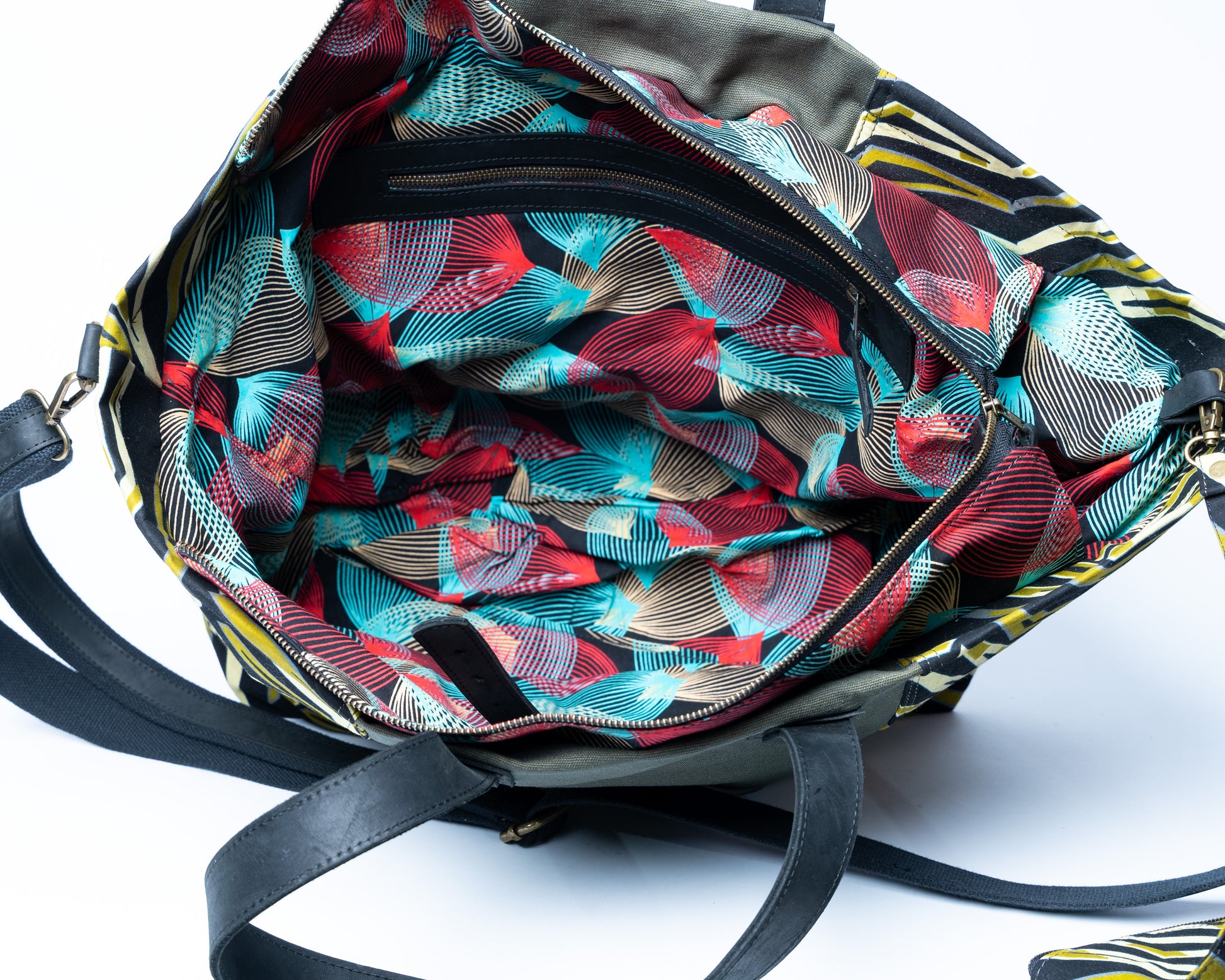 Colorful patterned bag with black straps on a white background