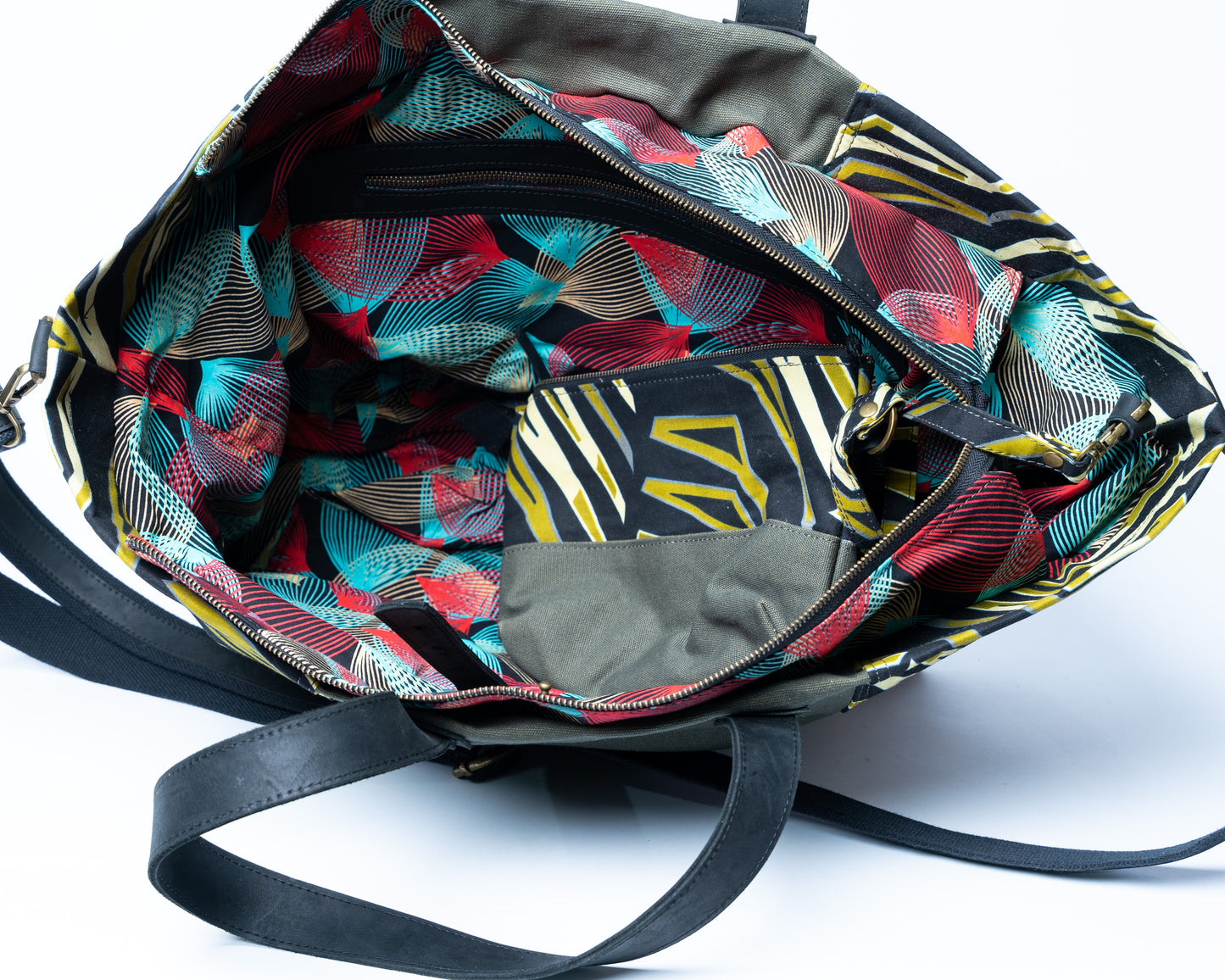 Colorful patterned bag with a black strap on a white background