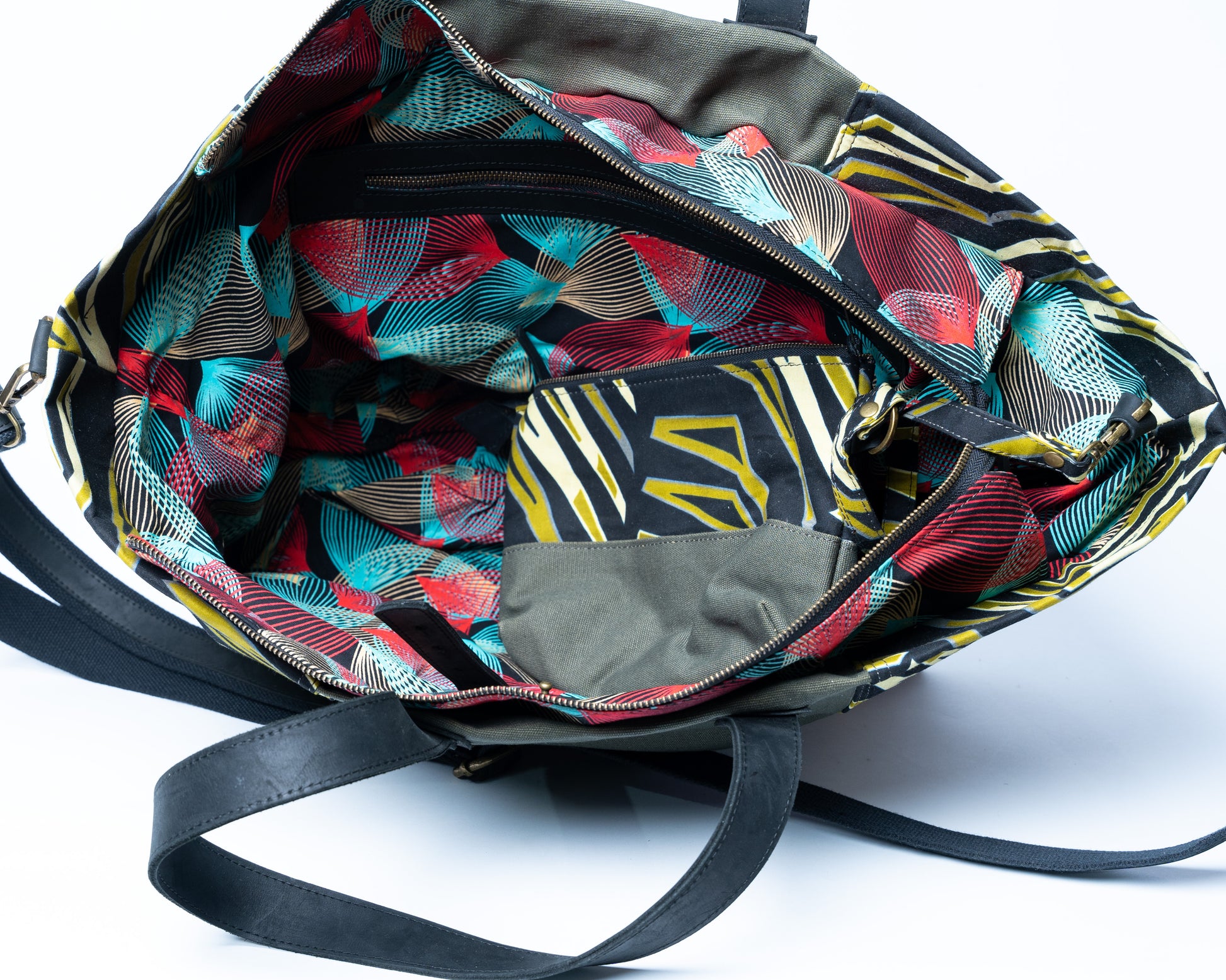 Colorful patterned bag with a black strap on a white background