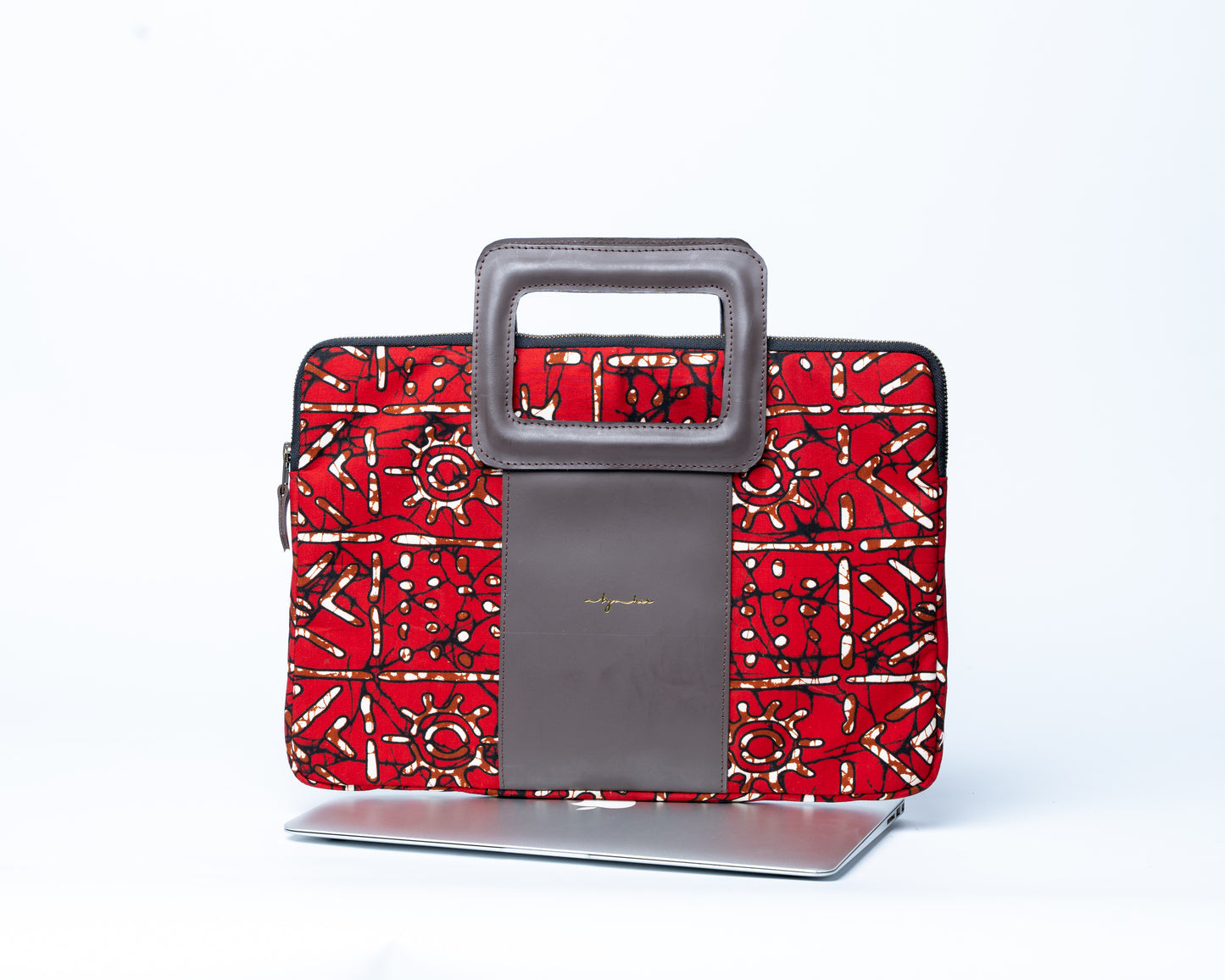 Red patterned laptop sleeve with a gray handle on a white background